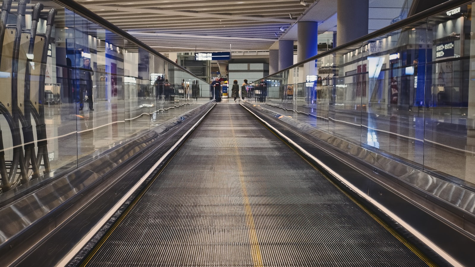空港ターミナルを行き交う旅行者と動く歩道