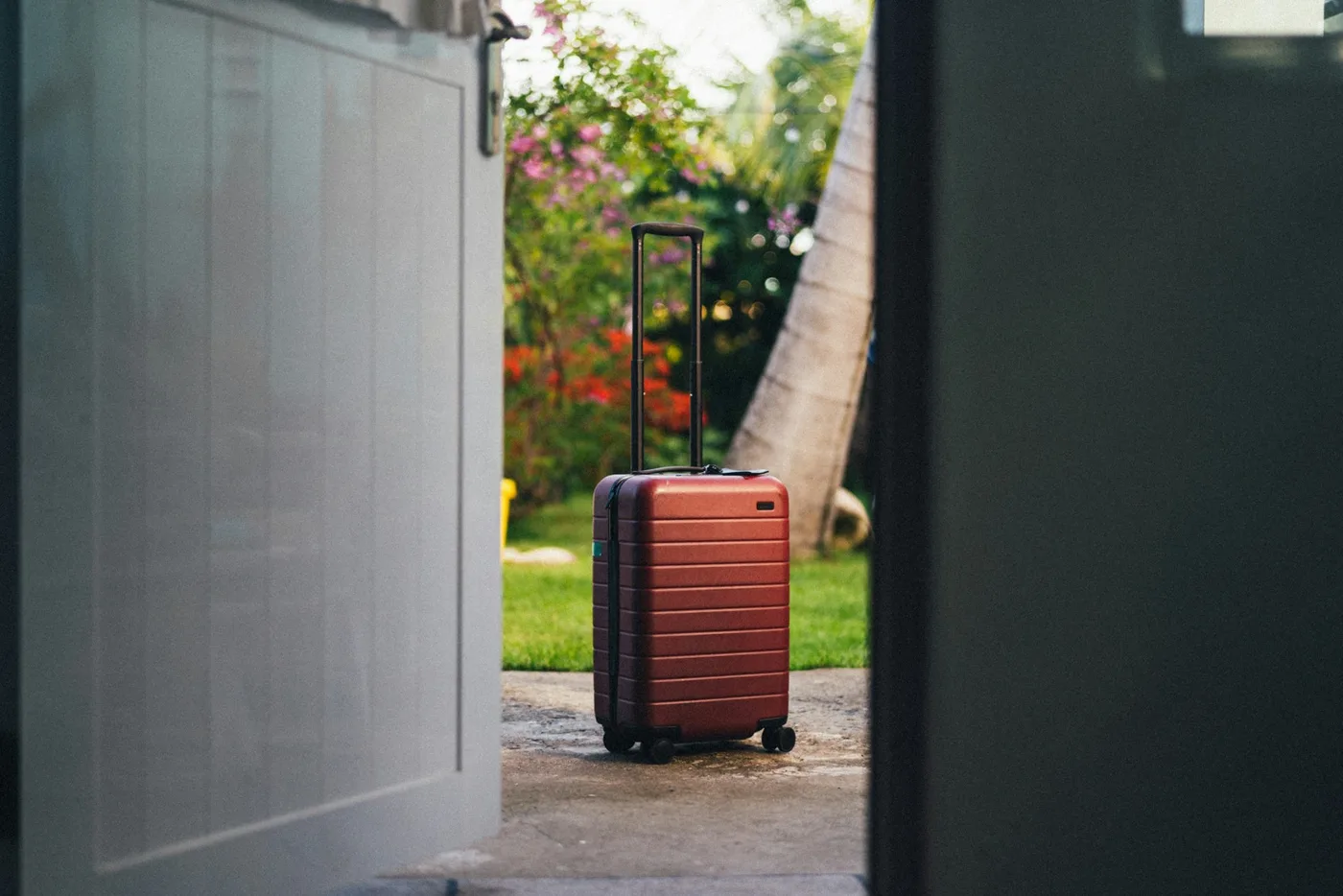 玄関先に置かれた小型のハードケーススーツケース