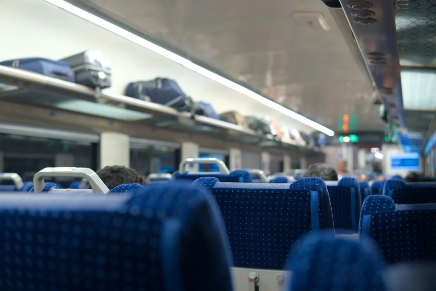 列車の荷物棚に載せられたスーツケースとボストンバッグ